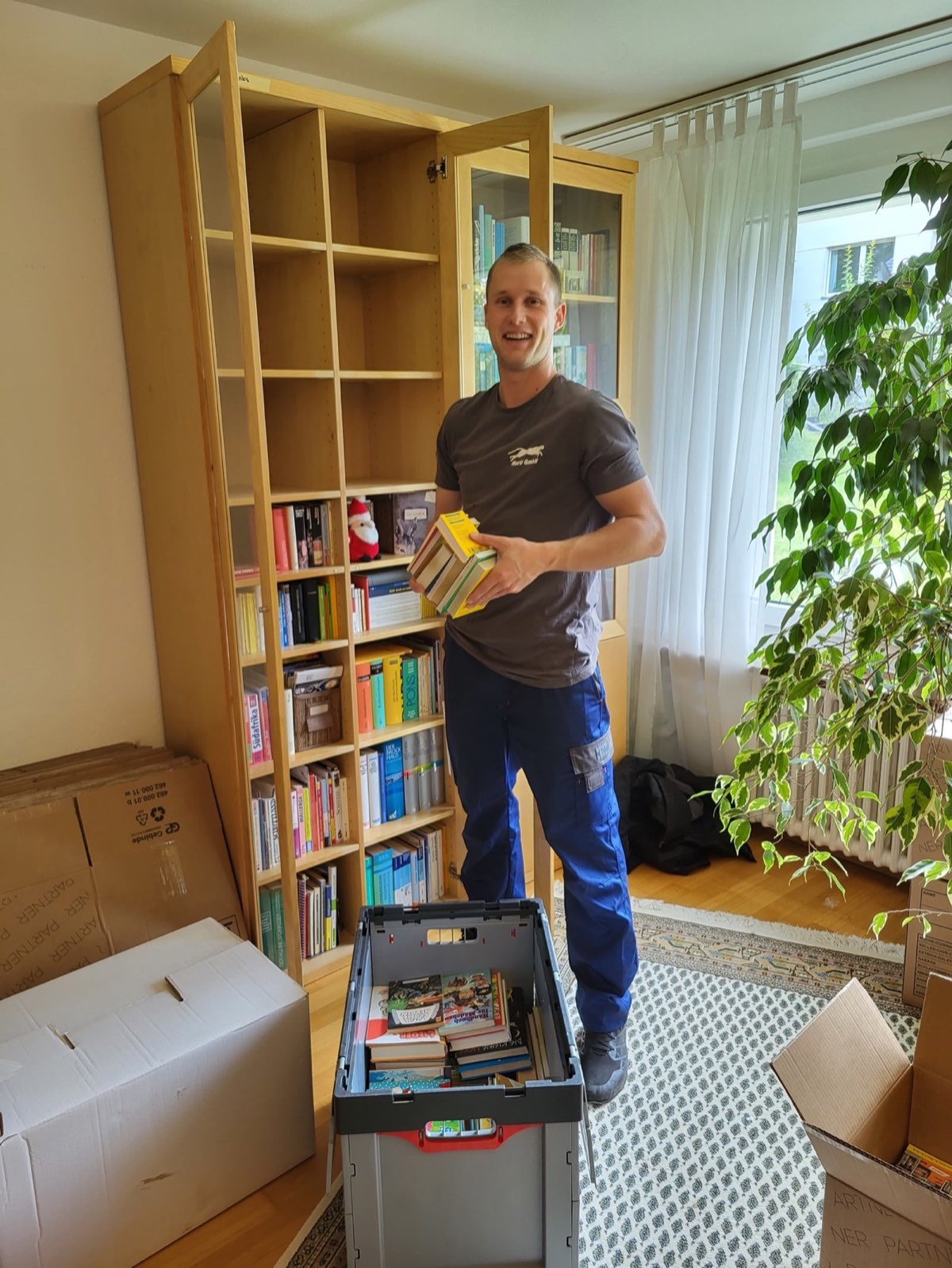 Sorgfältiges Einräumen eines Bücherregals - Geschulte Umzugshelfer